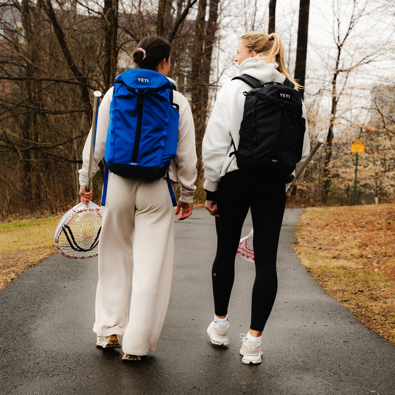 Two people walking together with YETI Palo backpacks on their backs.