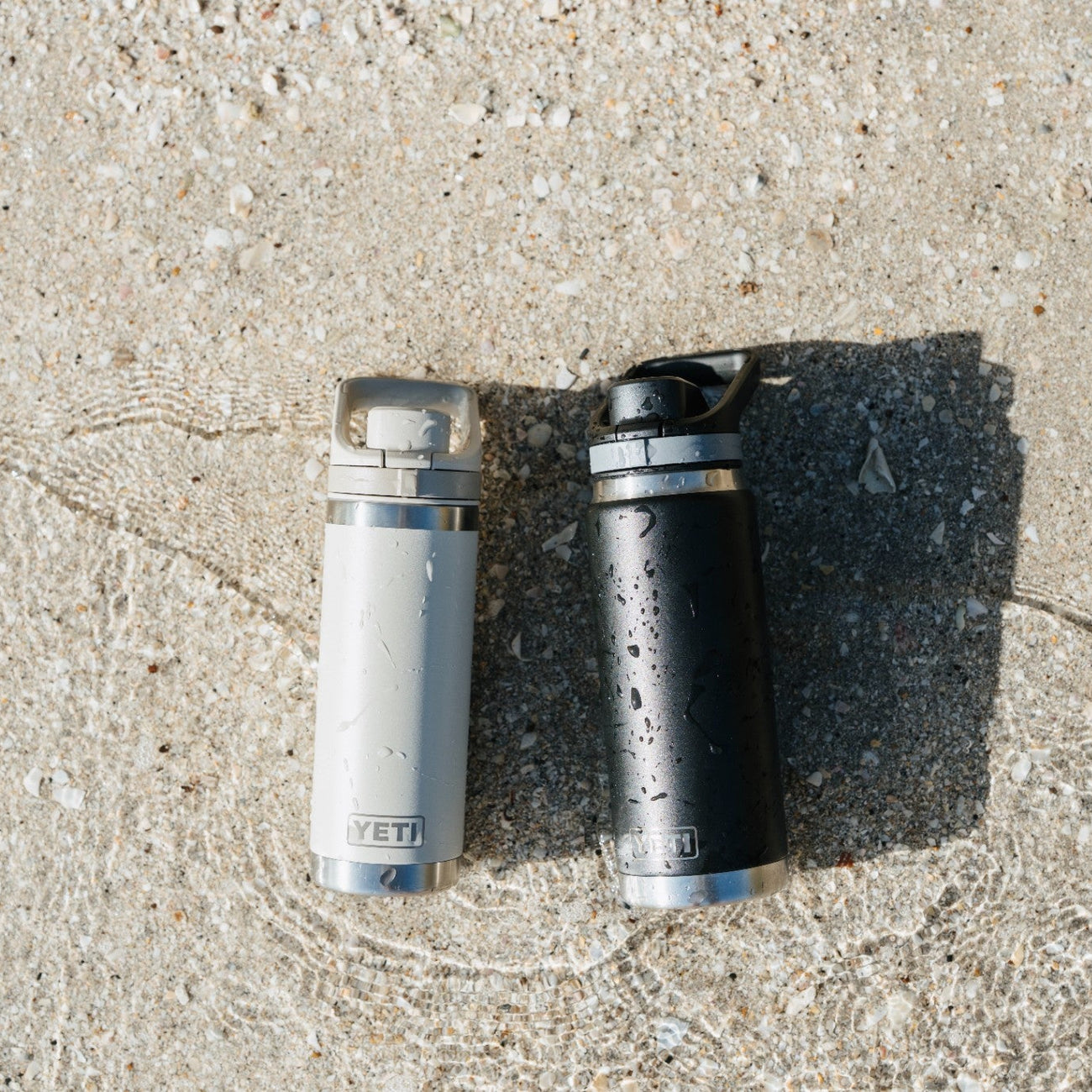 Two water bottles on a beach surface